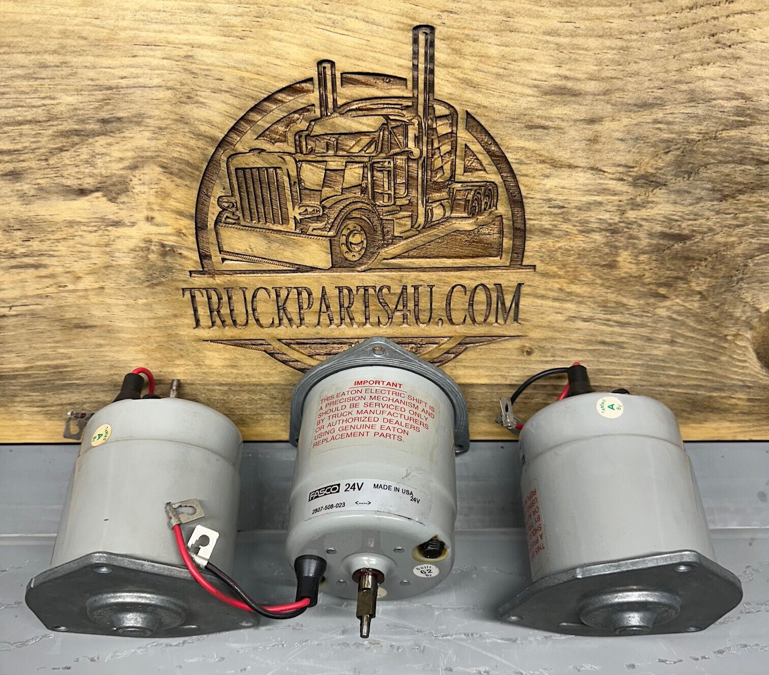 Three Eaton/Dana-Spicer 24V 2-speed differential lock shift motors (part 40638 / 040638) front view with labels and wiring pigtails, NOS OEM for Eaton 113743